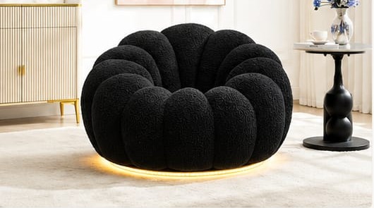 A round black bouclé swivel chair with warm LED underglow